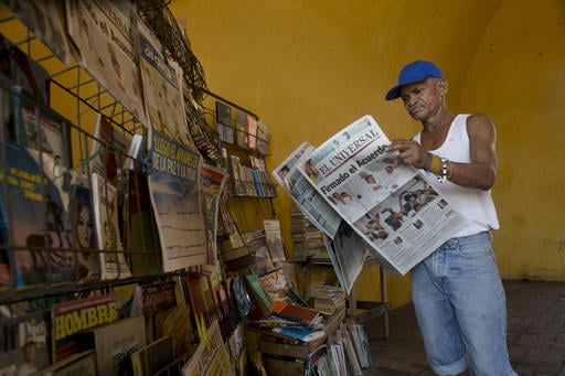 Saul Lambis reads a newspaper carrying the headline in Spanish "Agreement Signing" in Cartagena