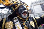 A member of the Krewe of Zulu marches during their parade Mardi Gras day in New Orleans