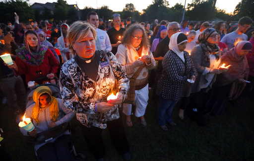 A few hundred supporters stand holding lit candles as they listen to comments from speakers during a vigil for Jordan Edwards in Balch Springs