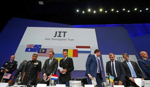 Members of the Joint Investigation Team (JIT) get to their feet after a press conference on the preliminary results of the investigation into the shooting-down of Malaysia Airlines jetliner flight MH17 in Nieuwegein