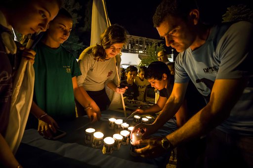 Israelis light candles in the Israeli settlement of Halamish