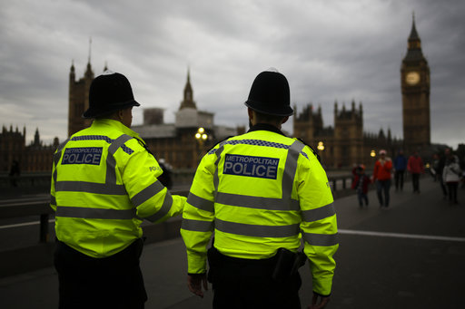 Police officers patrol Westminster Bridge with the Houses of Parliament in the background
