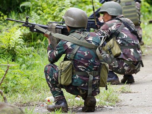 Government troops take positions as fighting with Muslim militants in Marawi city enters its second week Tuesday