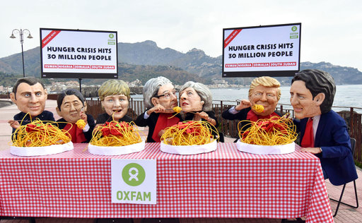 Activists wearing the masks of the seven leaders of G7