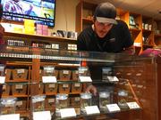 Torrey Holistics employee Taron McElroy arranges jars of cannabis in San Diego