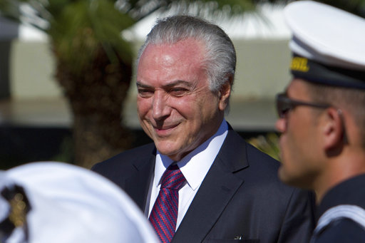 Brazil's President Michel Temer smiles as he receives military honors during ceremony