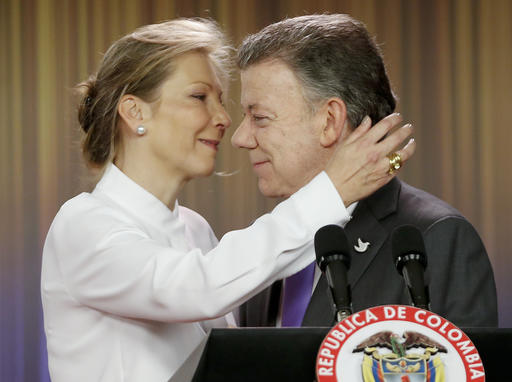 Colombia's President Juan Manuel Santos is embraced by his wife Maria Clemencia Rodriguez after speaking to journalists at the presidential palace in Bogota