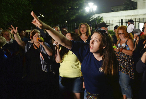 Opposition supporters shout slogans as they protest in front of the Senate building where a debate continues before a crucial vote to approve legislation that would give politicians substantial influence over the country's Supreme Court