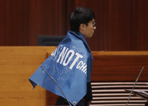 Newly elected lawmaker Sixtus Leung of  Youngspiration wears a banner with words reading "Hong Kong is not China as he takes oath in the new legislature Council in Hong Kong