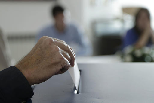 A Bosnian Serb man casts his ballot at a poling station during referendum in the Bosnian town of Laktasi