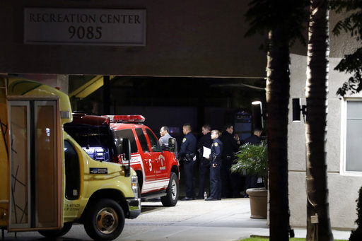 Police officers stand guard in front a La Jolla apartment building after a shooting Sunday