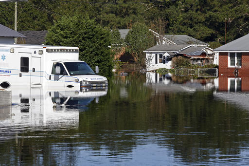 Floodwaters associated with Hurricane Matthew surround homes and an ambulance on Thursday