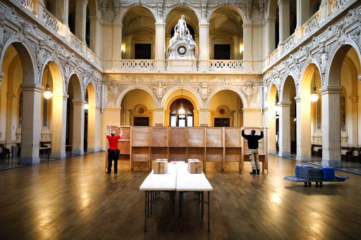 Workers prepare voting booths at a polling station in Lyon