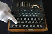 H. Keith Melton points to a key on an Enigma Machine with four rotors and a some Japanese characters that was used in World War II to encode messages