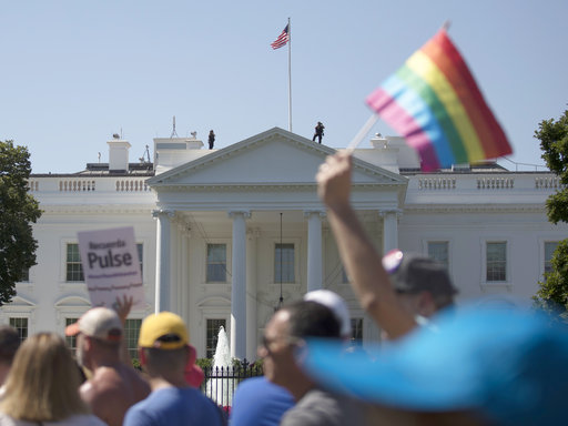 Equality March for Unity and Pride participants march past the White House in Washington
