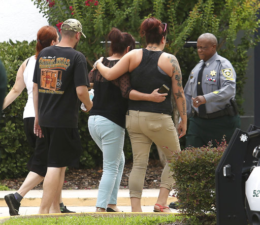 People arrive at a staging center setup by the Orange County Sheriff's Office after a deadly shooting Monday