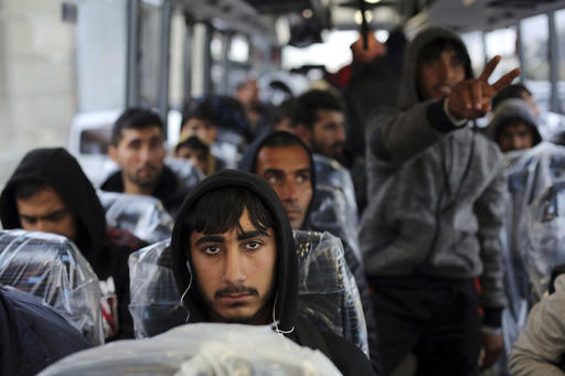 Migrants sit on a bus going to Normandy
