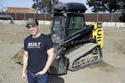 Built Robotics CEO Noah Ready-Campbell poses for a picture in front of the company's autonomous track loader Wednesday