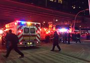 First responders carry a person to an ambulance after a helicopter crashed into the East River along New York on Sunday