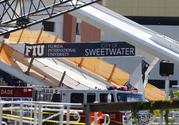 A sign above the rubble of a new pedestrian bridge is shown after the bridge collapsed onto a highway at Florida International University in Miami on Thursday