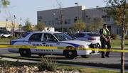 A police officer stops a vehicle at a check point in front of a FedEx distribution center where a package exploded