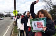 Su Sheridan holds a sign protesting proposed cuts to retirement benefits for public school teachers on Thursday