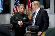 President Donald Trump shakes hands with Broward County Sheriff Scott Israel as he meets with law enforcement officers at Broward County Sheriff's Office in Pompano Beach