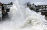 A large wave crashes into a seawall in Winthrop