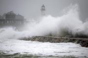 Waves crash against a seawall near the Scituate Lighthouse