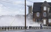 A woman takes pictures of the high surf