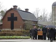 Pallbearers carry the casket of the Rev. Billy Graham past family members as it returns to the Billy Graham Library in Charlotte