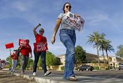 Arizona teachers march in protest of their low pay and school funding in front of a local radio station waiting for Republican Gov. Doug Ducey to show up for a live broadcast Tuesday