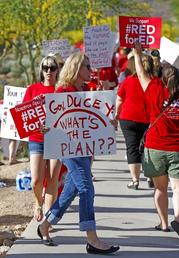 Arizona teachers march in protest of their low pay and school funding in front of a local radio station waiting for Republican Gov. Doug Ducey to show up for a live broadcast Tuesday