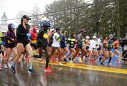 The elite female runners break from the starting line in a downpour during the 122nd running of the Boston Marathon in Hopkinton