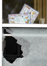 Menus and a cup sit on a table next to a window shot out at a Waffle House restaurant Sunday