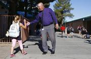 Principal Shawn Duguid welcomes a student back to Oakwood Elementary School after a statewide Arizona teachers strike ended Friday