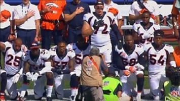 Denver Broncos players in 2017 taking a knee during the National Anthem.