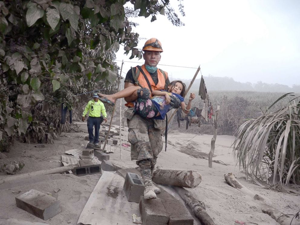 PHOTO: A Guatemalan rescue team worker carries a girl in El Rodeo, Escuintla, Guatemala, June 3, 2018, after the eruption at Fuego volcano, which has left at least 25 dead, around 20 injured and more than 1.7 million people were affected.