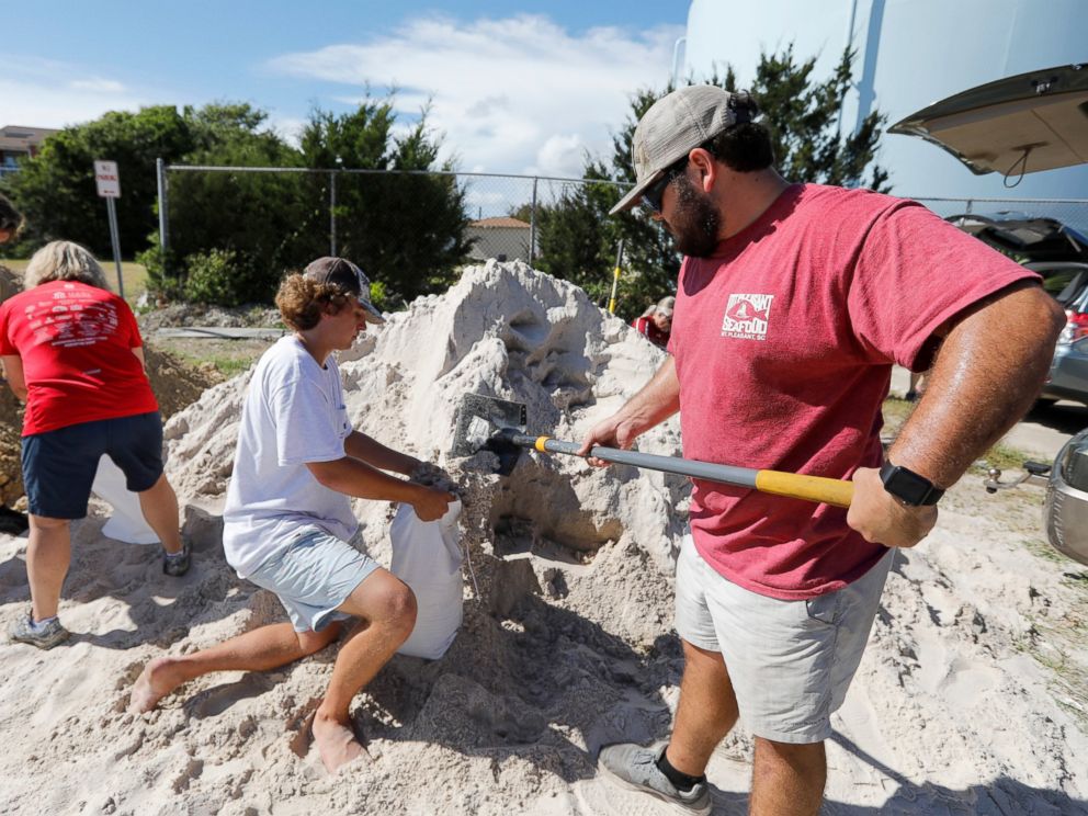 PHOTO: Walker Townsend, at right, from the Isle of Palms, S.C., fills a sand bag while Dalton Trout, in center, holds the bag at the Isle of Palms municipal lot in preparation for Hurricane Florence at the Isle of Palms S.C., Monday, Sept. 10, 2018.