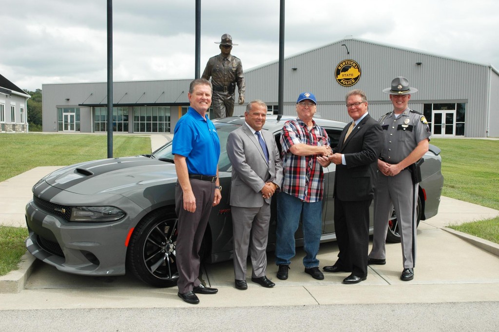 Kimmy Smith (center) of Louisville receives keys to new 2018 Dodge Charger as winner of annual KSP Trooper Island Raffle.  Pictured left to right:  Bob Allen