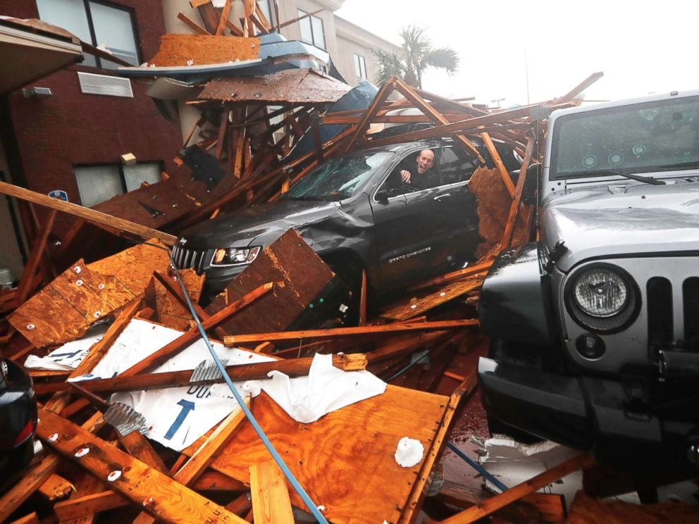 PHOTO: A storm chaser climbs into his vehicle during the eye of Hurricane Michael to retrieve equipment after a hotel canopy collapsed in Panama City Beach, Fla., Oct. 10, 2018.