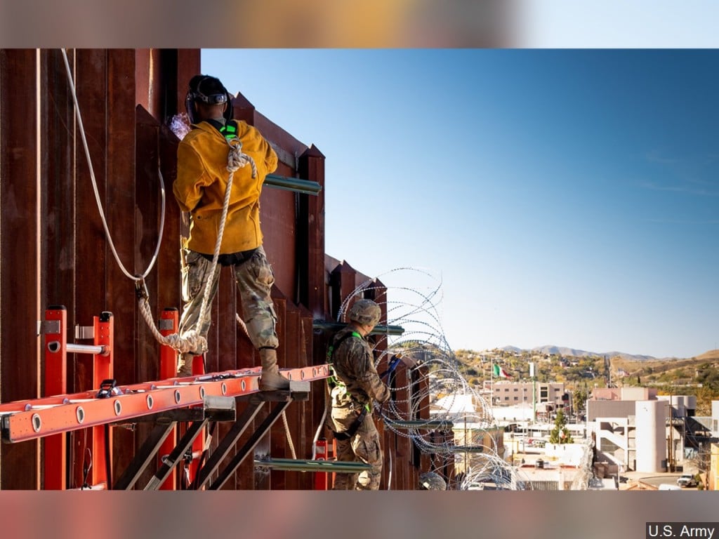Members of the U.S. Army installing concertina wire on the border wall east of the Port of Nogales