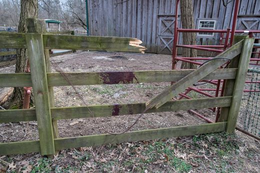 A fence is broken and marked with blood after a llama tried to escape an attack by an unknown group of canines on a 16-acre farm that is situated near the Louisville Zoo and I-264 in a suburban area. Source: Courier Journal