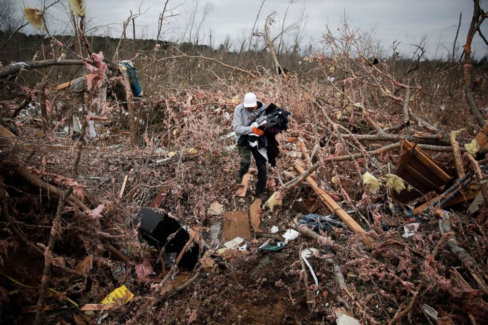 PHOTO: Dax Leandro salvages clothing from the wreckage of his friends home after two back-to-back tornadoes touched down, in Beauregard, Ala., March 4, 2019.