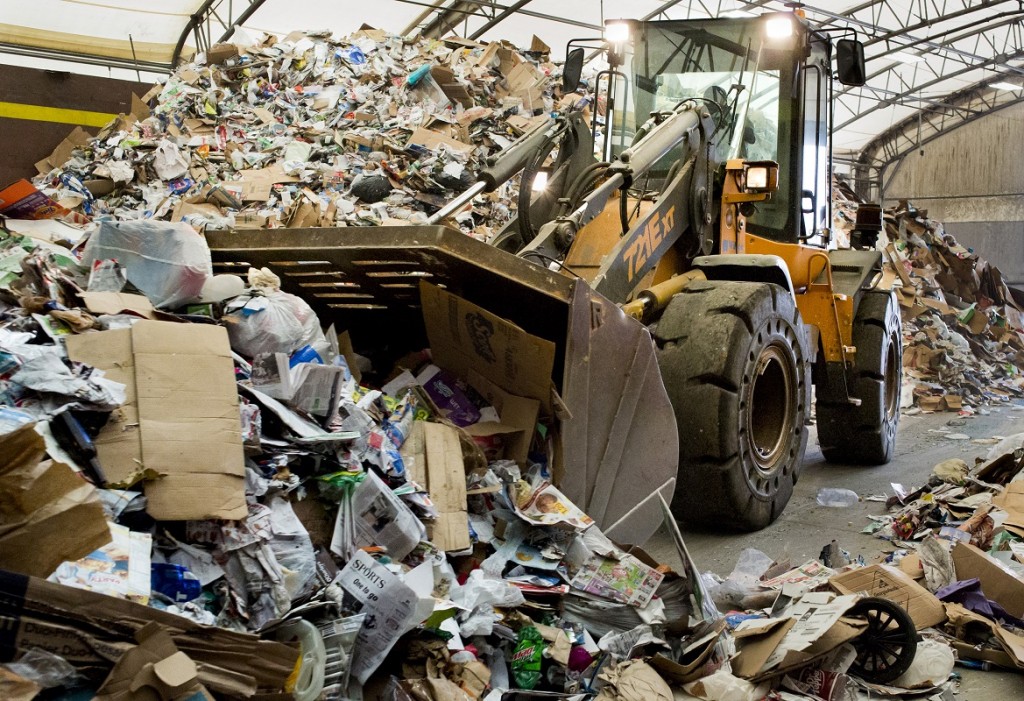 Front loader pushing recyclables that were just dropped off in the first step of the sorting pricess at the recycling center.