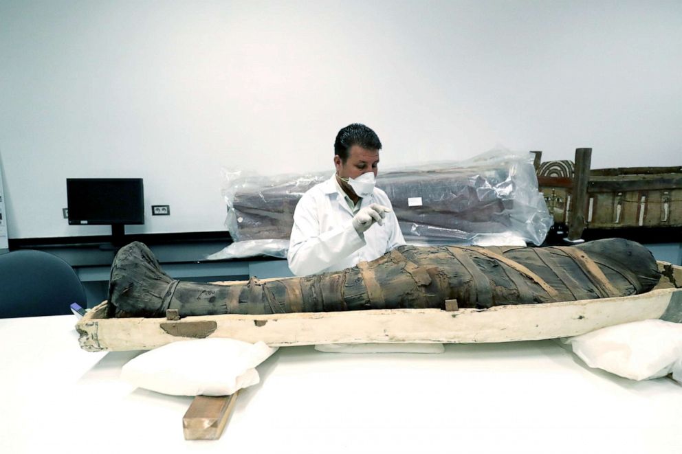 PHOTO: An Egyptian archaeologist checks the mummy during restoration work on the coffin of King Tutankhamun at the conservation center in the Grand Egyptian Museum, Aug. 4, 2019.