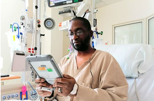Army Veteran Tracy Dunigan using a donated iPad mini to connect with loved ones while hospitalized in Lexington during the coronavirus outbreak which led to patient visitor restrictions