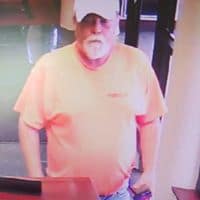 Security camera image of man accused of trying to pass a forged check at a bank in Corbin