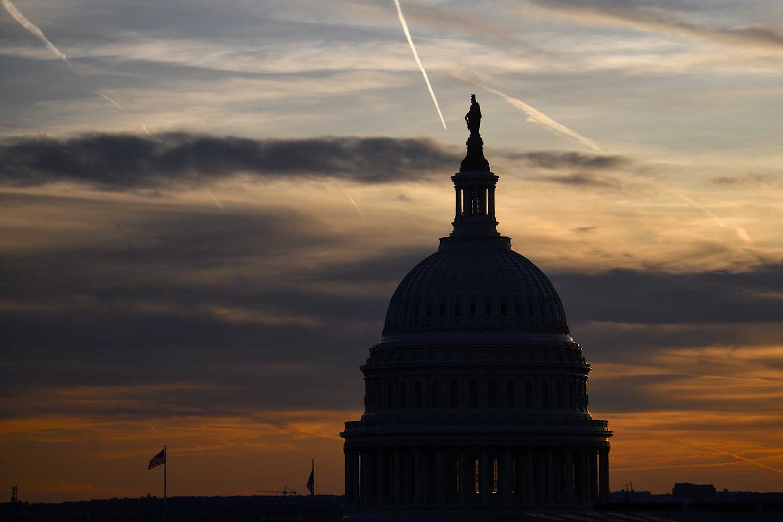 Streaks in the sky form at sunset behind the U.S. Capitol Building on November 13, 2019 in Washington.
