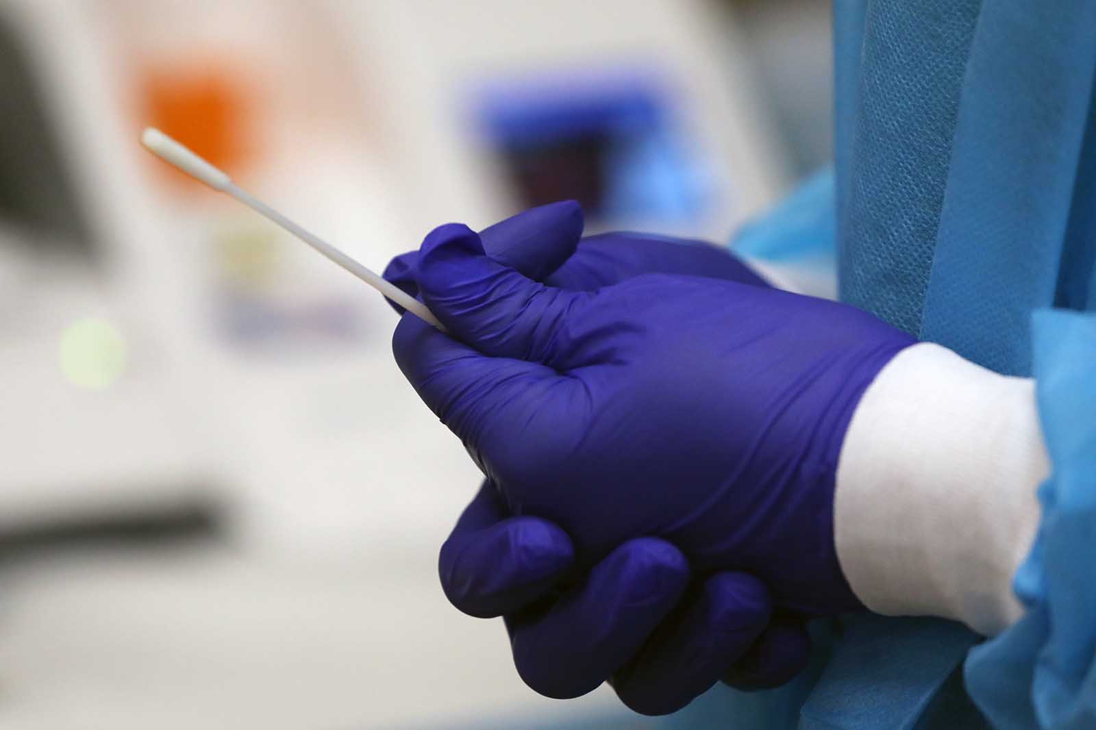 A medical worker shows the process for rapid coronavirus testing on the new Abbott ID Now machine at a ProHEALTH center in Brooklyn on August 27, in New York City.